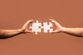 Holding puzzle. Business solutions, success and strategy concept. Two hands trying to connect couple puzzle piece on Royalty Free Stock Photo