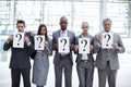 Holding questions, looking for answers. Concept shot of a diverse group of business executives holding up placards with Royalty Free Stock Photo
