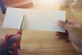 Holding scissors and cutting blank white paper