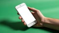 Is holding a smartphone with a blank white screen over a green Royalty Free Stock Photo