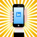 Holding smartphone with Linkedin logo