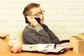 holding and speaking on cell phone on white brick wall background, copy space. young cute businessboy Royalty Free Stock Photo