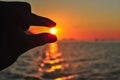 holding the sun with a finger at a very beautiful sunset. Beautiful Sunset in tropical Komodo island, Labuan Bajo, Fores,