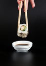 Holding sushi roll,Sushi roll on soy sauce,japanese food. Royalty Free Stock Photo