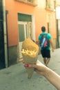 Holding typical potato fries in hand in the streets