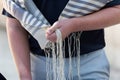 Holding tzitzit strings on a prayer shawl during Jewish prayer