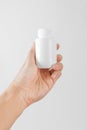 Holding a white bottle of pills Royalty Free Stock Photo