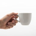 Holding a white ceramic mug by its handle against a plain white Royalty Free Stock Photo