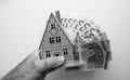 an Holding Wooden Dream House with Japanese Fan Banknotes - Monochrome Property