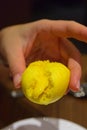 Holding Yellow Custard Bun with the filling oozing out