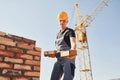 Holds bricks in hands. Construction worker in uniform and safety equipment have job on building Royalty Free Stock Photo