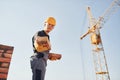 Holds bricks in hands. Construction worker in uniform and safety equipment have job on building Royalty Free Stock Photo