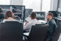 Holds document in hands. Team of stockbrokers works in modern office with many display screens Royalty Free Stock Photo