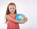 She holds the future in her hands. A cute little girl holding a globe and smiling at the camera. Royalty Free Stock Photo