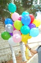 She holds multicolored balloons in her hand green background . The girl has multicolored balloons in her hands Royalty Free Stock Photo