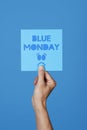 Holds a sign with the text blue monday Royalty Free Stock Photo