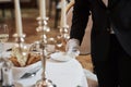 Holds white plate. Process of preparing place for special visitors. Waiter in classical wear works on the servering Royalty Free Stock Photo