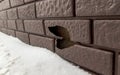 A hole on a broken siding on the wall of a house