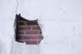 Hole in broken wall and old bricks on a white background. Large crack on the wall of an old brick house, crumbling plaster and Royalty Free Stock Photo