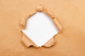 Hole into brown craft paper sheet with torn edges. White center isolated, clipping path included. Top view Royalty Free Stock Photo
