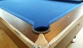 A hole in the corner of a pool table with a wooden border Royalty Free Stock Photo