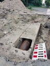 In the hole dug on the road, there is a sewage pipe that is being repaired by the road services Royalty Free Stock Photo