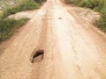 Hole on dusty soil road in countryside Royalty Free Stock Photo