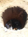 hole in the ground, made by hand for the purpose of depositing garbage and burning