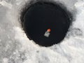 Hole in the ice, a short pole for ice fishing Royalty Free Stock Photo