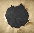 Hole made of torn paper over textured black background Royalty Free Stock Photo