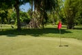 Hole marked with red flag at the mini golf area Royalty Free Stock Photo