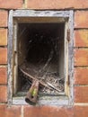 Hole in a red brick column, outdoors, in which a small shovel is placed Royalty Free Stock Photo