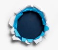 Hole ripped in white and blue paper Royalty Free Stock Photo