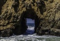 A Hole in a rocky peak in the ocean Royalty Free Stock Photo