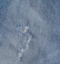 Hole and Threads on Denim Jeans. Ripped Destroyed Torn Blue jeans background. Close up blue jean texture Royalty Free Stock Photo