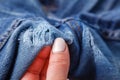 Hole and Threads on Denim Jeans. Ripped Destroyed Torn Blue jeans background. Close up blue jean texture Royalty Free Stock Photo