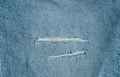 Hole and Threads on Denim Jeans. Ripped Destroyed Torn Blue jeans background Royalty Free Stock Photo