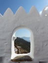 Hole on a white wall with behind a landscape to Amorgos in the Cyclade Islands in Greece.