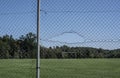 A hole in a wire mesh fence Royalty Free Stock Photo