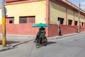 Holguin, Cuba 12/12/2018 Cyclo taxi or rickshaw with passenger on colourful road