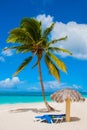 Holguin, Cuba, Playa Esmeralda. Beautiful Caribbean sea turquoise blue color and palm trees on the beach. Sun loungers and umbrell Royalty Free Stock Photo