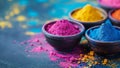 Holi background. Bowls of colorful rainbow gulal powder on blue table