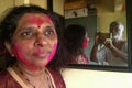 Holi Festival Colors on woman face photographed by her husband in Mirror Blurred image Lokgram Kalyan