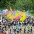Holi, festival of colours, festival of love. Abstract crowd of blurry unrecognizable happy young people, vivid dust Royalty Free Stock Photo