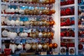 White, golden and red Christmas ornaments in shape of glass balls hanging on shelves at Christmas fair in Berlin Germany Royalty Free Stock Photo