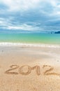 Holiday background, 2012 written on sand of beach Royalty Free Stock Photo