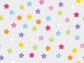 Holiday background with colorful star confetti scatter on white background. Seamless patern vector illustration