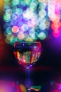 Holiday background. Glass of wine, champagne on background of multi-colored bokeh. Concept solemn feast, congratulations Royalty Free Stock Photo