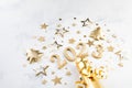 Holiday background with golden Christmas decorations and New year 2023 numbers and confetti stars