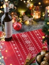 Holiday background with red napkin, meal, glasses, bottle of wine, candles, fir branches, festive decoration, garland. Christmas Royalty Free Stock Photo